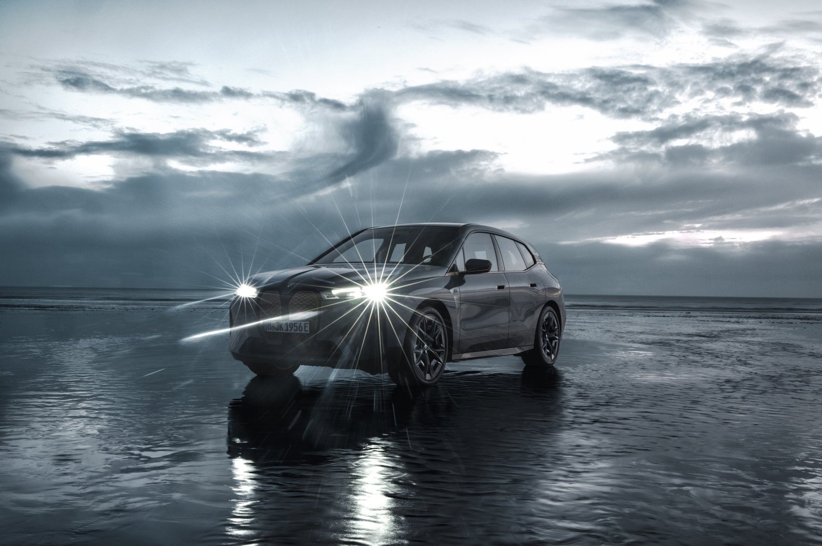 Car with gray cloudy background with its headlights on.